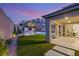 Well-maintained backyard showcasing a lawn, outdoor kitchen, sparkling pool, and covered patio at 389 Red Feather Peak Ct, Las Vegas, NV 89138