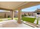 Covered patio with modern design elements, an outdoor kitchen, and an artificial lawn at 389 Red Feather Peak Ct, Las Vegas, NV 89138