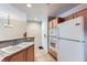 Functional kitchen featuring a breakfast bar, granite countertops, and white appliances at 43 E Agate Ave # 302, Las Vegas, NV 89123