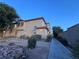 Inviting two-story townhouse with desert landscaping, warm lighting, and a private walkway at 558 Roxella Ln # D, Las Vegas, NV 89110