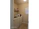 Well lit laundry room featuring a washer and dryer plus storage shelving at 5651 Bettors Luck Ct, Las Vegas, NV 89122