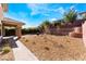 Large backyard featuring desert landscaping, a small fire pit, and a brick retaining wall at 5735 Oak Bend Dr, Las Vegas, NV 89135