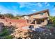 Large backyard featuring desert landscaping, a small fire pit, and a brick retaining wall at 5735 Oak Bend Dr, Las Vegas, NV 89135