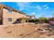 A spacious backyard with desert landscaping, young trees, and a cozy fire pit area for outdoor gatherings at 5735 Oak Bend Dr, Las Vegas, NV 89135