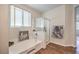 Bright bathroom features a tub, glass-enclosed shower, and a large window for natural light at 5889 Wildhorse Ledge Ave, Las Vegas, NV 89131