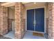 Welcoming home entrance featuring a blue double door framed by stone pillars and a 'welcome' mat at 5889 Wildhorse Ledge Ave, Las Vegas, NV 89131