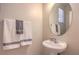 Cozy half-bathroom featuring a pedestal sink, round mirror, and decorative towels for guests at 5889 Wildhorse Ledge Ave, Las Vegas, NV 89131