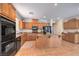Spacious kitchen featuring an island, granite countertops, wood cabinets and black appliances at 5889 Wildhorse Ledge Ave, Las Vegas, NV 89131
