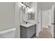 Modern bathroom boasts a vanity with gray cabinets, quartz countertops, and updated lighting at 632 Hitchen Post Dr, Henderson, NV 89011