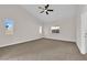Bright bedroom featuring a ceiling fan, neutral carpeting, and a sunny window at 632 Hitchen Post Dr, Henderson, NV 89011