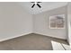 Bright bedroom with neutral walls and carpet, a ceiling fan, and a window bringing in light at 632 Hitchen Post Dr, Henderson, NV 89011