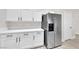 Bright kitchen featuring stainless steel refrigerator and white cabinets with dark hardware at 632 Hitchen Post Dr, Henderson, NV 89011
