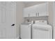 A neat laundry area offers convenient white washer, dryer, and upper cabinets at 632 Hitchen Post Dr, Henderson, NV 89011