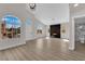 Vaulted living room features a front door, arched windows, light wood flooring, and a fireplace at 632 Hitchen Post Dr, Henderson, NV 89011