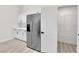 An open pantry with wire shelving and new stainless steel refrigerator provides ample storage space at 632 Hitchen Post Dr, Henderson, NV 89011