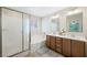 Bright bathroom featuring a dual sink vanity, soaking tub, and a separate glass-enclosed shower at 6713 Guidestar St, North Las Vegas, NV 89084