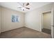 This carpeted bedroom has a ceiling fan, window, and entrance to the bathroom at 6713 Guidestar St, North Las Vegas, NV 89084