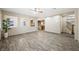 Open-concept living area with wood laminate flooring, windows, and view to the kitchen at 6713 Guidestar St, North Las Vegas, NV 89084