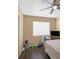 Bedroom with tan walls, dark laminate flooring, blinds and a ceiling fan at 7026 Westpark Ct, Las Vegas, NV 89147