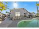 A gray single-story home has a sparkling swimming pool and a patio with plenty of seating and a sliding door to the interior at 7026 Westpark Ct, Las Vegas, NV 89147