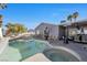 Lovely backyard features a sparkling swimming pool and spa with ample lounge chairs and covered patio with outdoor dining set at 7026 Westpark Ct, Las Vegas, NV 89147