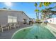 Backyard swimming pool is surrounded by plenty of seating, mature landscaping and a lovely single-story home with sliding door access at 7026 Westpark Ct, Las Vegas, NV 89147