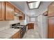 Eat-in kitchen featuring tile countertops, wood cabinets, and white appliances, and tile flooring at 7212 Nordic Lights Dr, Las Vegas, NV 89119