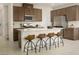 Modern kitchen with a large island, stainless steel appliances, dark cabinets, and bar stool seating at 7388 Daly Grove St, Las Vegas, NV 89113