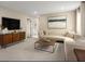 Cozy living room area with a large TV, comfortable seating, a stylish coffee table, and modern art at 7388 Daly Grove St, Las Vegas, NV 89113