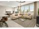 Bright and airy living room with large windows, neutral decor, comfortable seating, and modern rug at 7388 Daly Grove St, Las Vegas, NV 89113