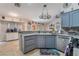Open kitchen with grey cabinets, stainless steel appliances, and adjacent coffee bar area at 7517 Elk Meadows Ct, Las Vegas, NV 89131