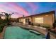 Twilight view of backyard featuring a sparkling pool, lush landscaping, and inviting pergola with seating at 7914 Elk Mountain St, Las Vegas, NV 89113
