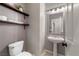 Charming powder room with stylish floating shelves, pedestal sink, and modern fixtures at 7914 Elk Mountain St, Las Vegas, NV 89113