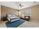 Spacious bedroom with ample natural light, a ceiling fan, tile flooring, and a cozy sitting area at 7914 Elk Mountain St, Las Vegas, NV 89113