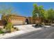 Exterior shot of a single story stucco home with a tile roof, desert landscaping, and an attached three-car garage at 7914 Elk Mountain St, Las Vegas, NV 89113