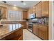 Bright kitchen showcasing stainless steel appliances, granite countertops, tile backsplash, ample cabinet space and a large island at 7914 Elk Mountain St, Las Vegas, NV 89113