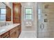 Elegant bathroom featuring a marble countertop, shower, and wood cabinetry at 8574 Verde Park Cir, Las Vegas, NV 89129