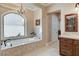 Opulent bathroom with soaking tub, arched window, and natural light at 8574 Verde Park Cir, Las Vegas, NV 89129