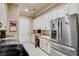 Laundry room with office featuring a stainless fridge, custom cabinets, and a built-in desk area at 8574 Verde Park Cir, Las Vegas, NV 89129