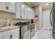 Well-equipped laundry room featuring custom cabinets, sink, and modern washer and dryer at 8574 Verde Park Cir, Las Vegas, NV 89129