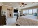Spacious bedroom featuring a fireplace, ceiling fan, and large windows at 8574 Verde Park Cir, Las Vegas, NV 89129