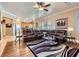 Open concept living space with hardwood floors, a sectional couch, and a view into the adjacent kitchen at 8698 Waterford Bend St, Las Vegas, NV 89123