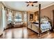Luxury main bedroom features a four-poster bed, hardwood floors, and an alcove sitting area at 8698 Waterford Bend St, Las Vegas, NV 89123