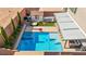 Backyard with a modern pool, spa, covered patio, sand box, and tall privacy trees at 8955 Ruby Moon Dr, Las Vegas, NV 89139