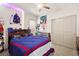 A bedroom with a ceiling fan, carpet flooring, built in shelves, a bed, and closet doors at 8955 Ruby Moon Dr, Las Vegas, NV 89139
