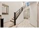 Bright entryway with wood floors, stairs with black railing and modern light fixture at 8955 Ruby Moon Dr, Las Vegas, NV 89139