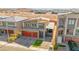 Modern two-story home with red garage doors, stylish stone accents, and solar panels in a suburban setting at 8955 Ruby Moon Dr, Las Vegas, NV 89139