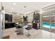 Modern kitchen features a granite island, stainless steel appliances, dark cabinets, and easy access to the outdoor pool area at 8955 Ruby Moon Dr, Las Vegas, NV 89139