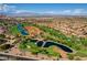 Expansive aerial view showcases the lush golf course and surrounding community under a clear blue sky at 9912 Woodhouse Dr, Las Vegas, NV 89134