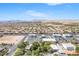 Aerial shot of a large Primary-planned community with businesses and desert landscape at 10445 Schirlls St, Las Vegas, NV 89141